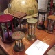 Mistress Troy examines hourglasses in a Manhattan antiquarian shop