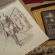 Dominatrix Mistress Troy receives a package from renowned femdom artist Sardax